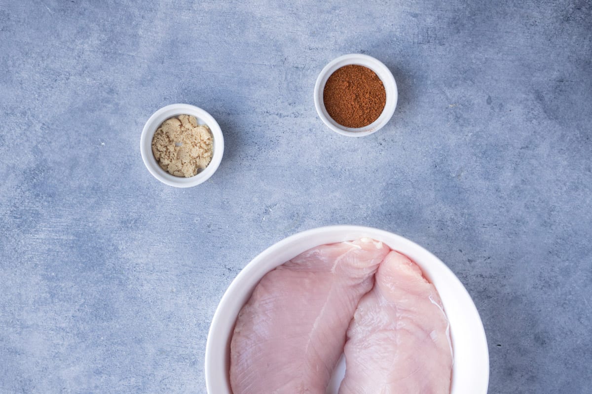 Ingredients you'll need to make the recipe, brown sugar in a small bowl and the seasoning and chicken tenderloins in a bigger bowl.