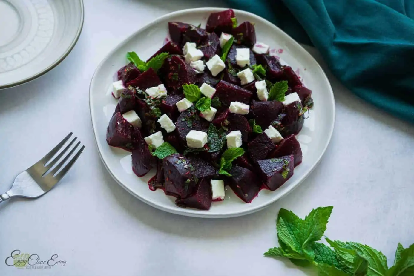 Feta and beet salad with fresh mint leave, a serving plate and a fork
