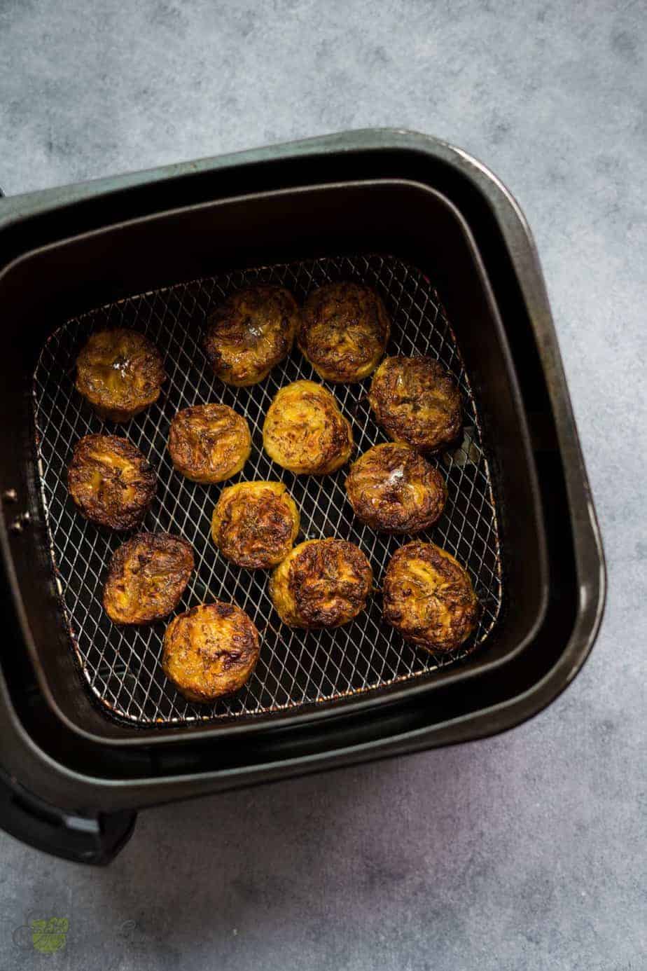 freshly fried plantains air fryer in the basket basket. with a golden brown color and crispy texture in the outside and soft and sweet inside.