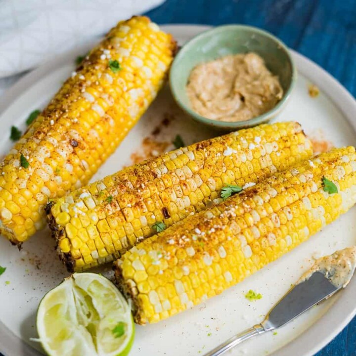 air fryer corn on the cob, serve with chili lime butter, sprinkle with paprika, goat cheese and fresh cilantro