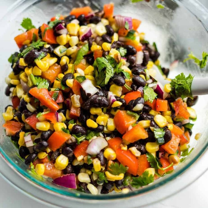 corn and black bean salsa in a mixing bowl with a spoon