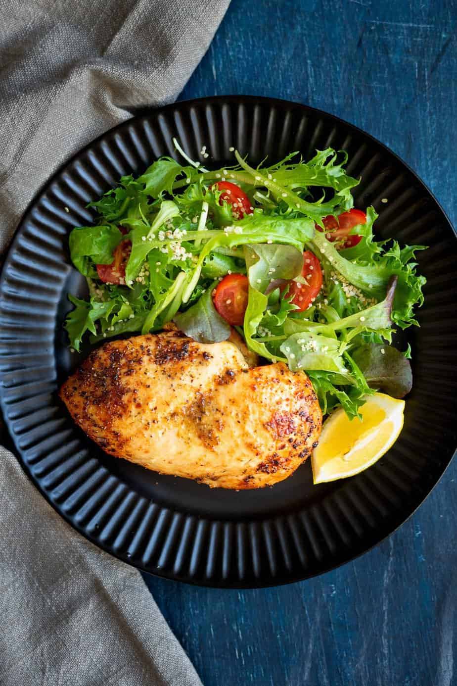 Excellently cooked chicken served with a salad of baby lettuces blend and cherry tomatoes.