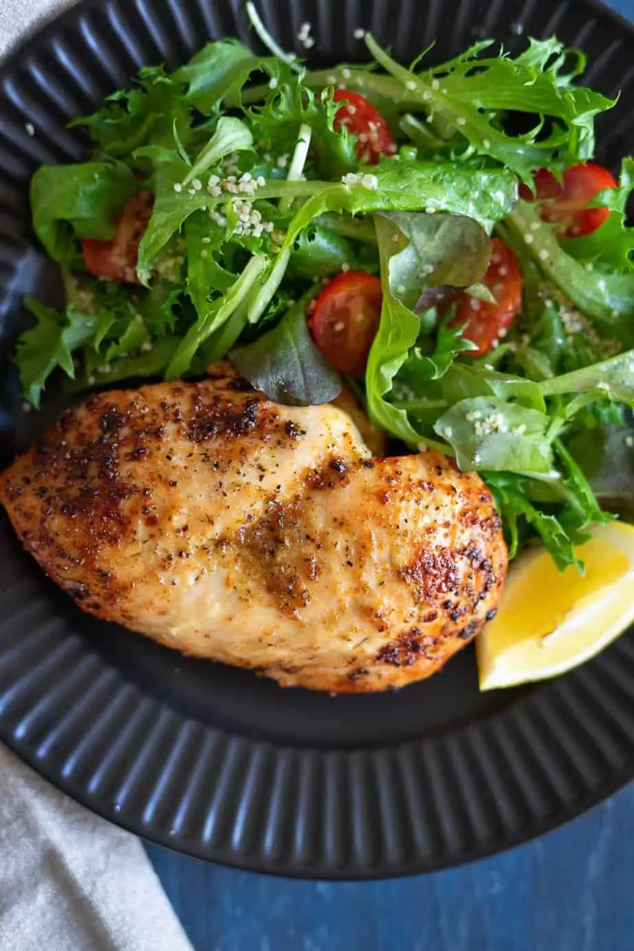 perfectly cooked frozen chicken breast served with a salad of baby lettuces mix and cherry tomatoes.