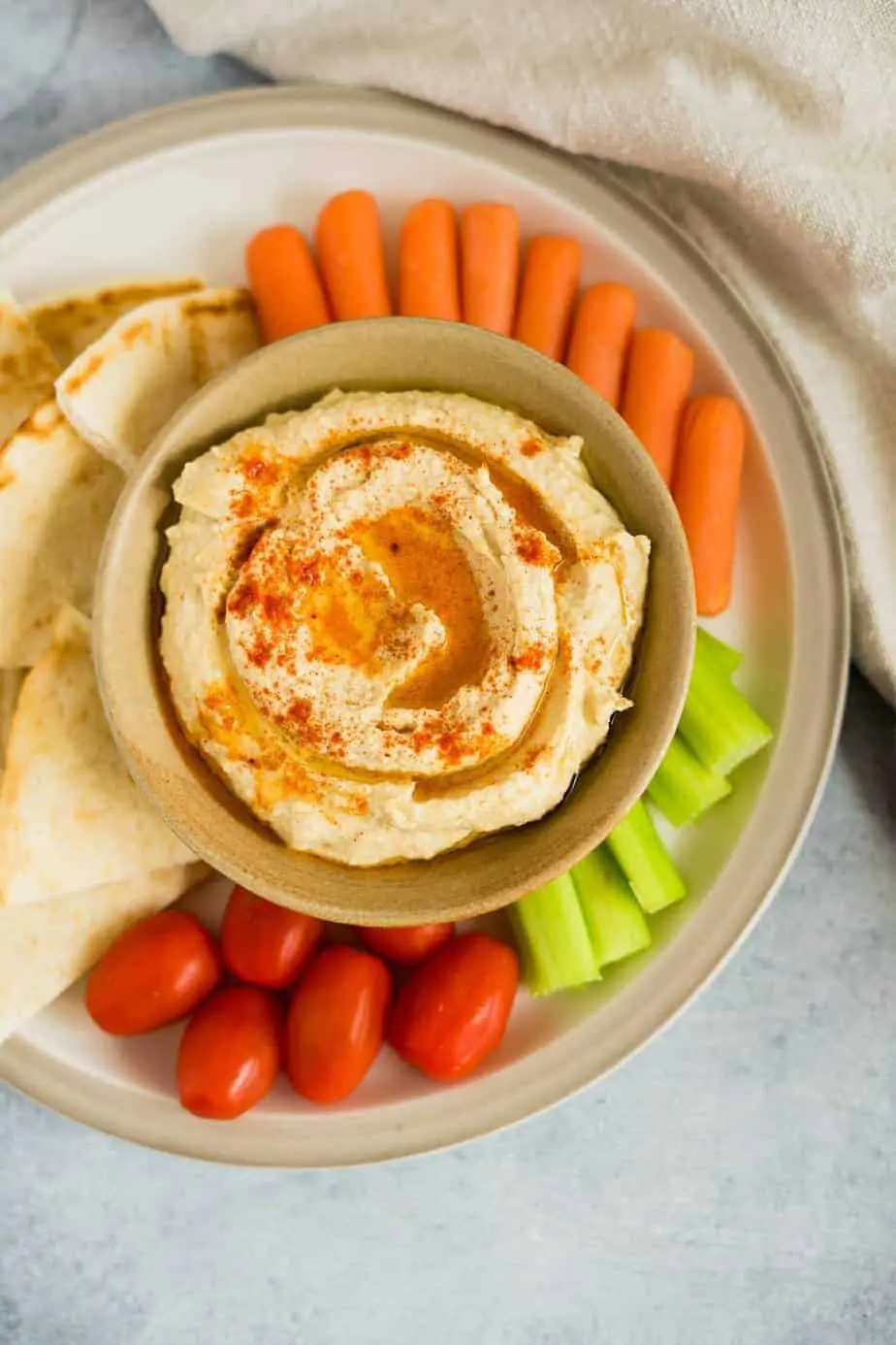 hummus instant pot served with a drizzle of olive oil and smoked paprika as a dip for fresh vegetables and pita bread.