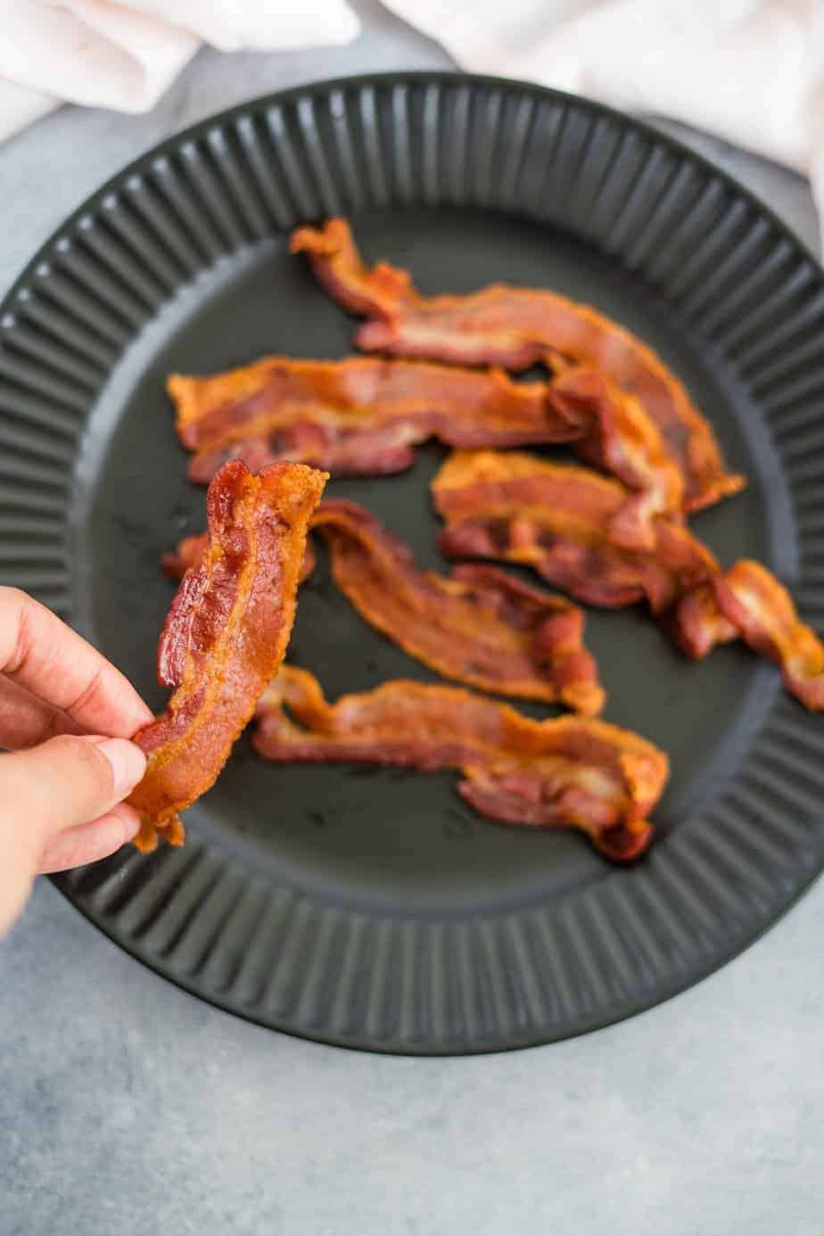 holding a crispy peace of bacon 