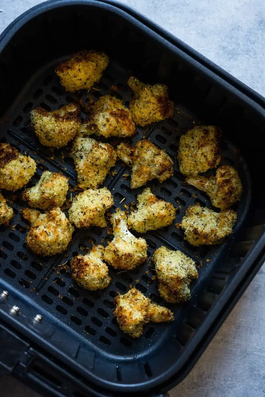 perfectly crispy cauliflower bites inside the air fryer basket after cooking.