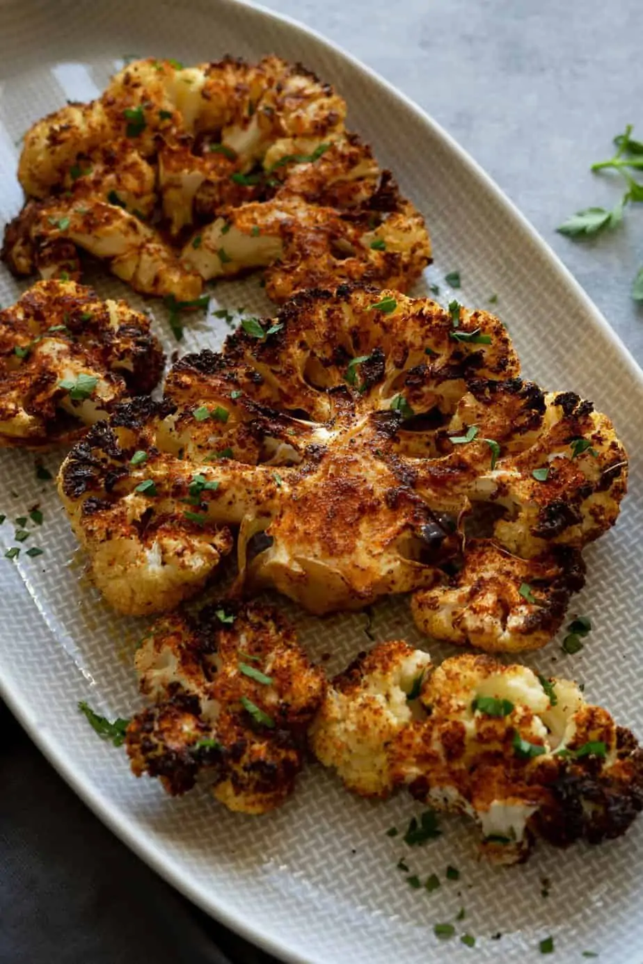 cauliflower steaks made in the air fryer with crispy edges and garnish with parsley.