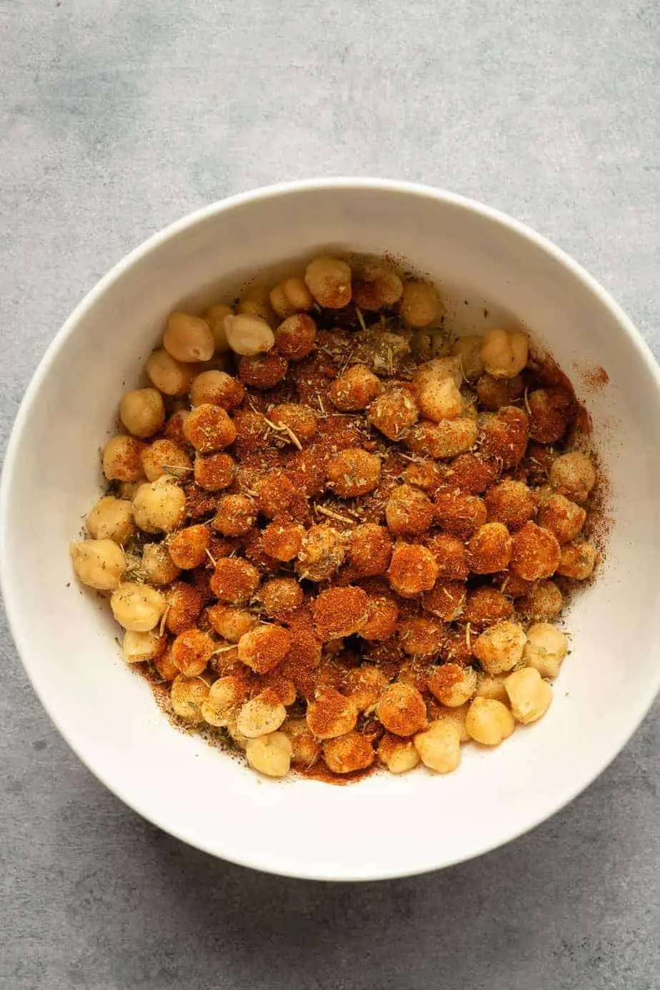 ingredients to make crispy chickpeas in the air fryer in a bowl before tossing.