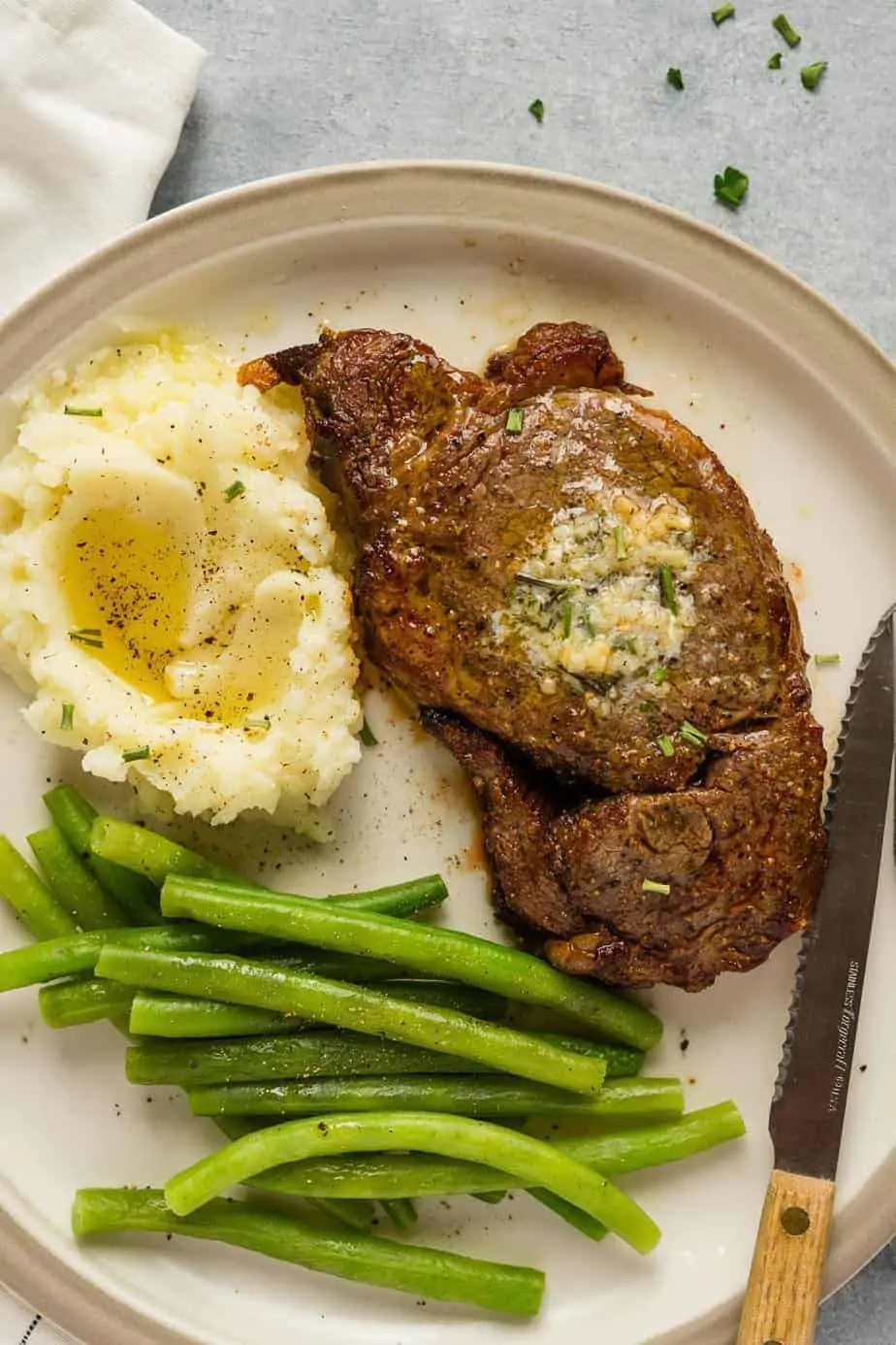 ribeye steak in the air fryer served with mashed cauliflower and steamed green beans