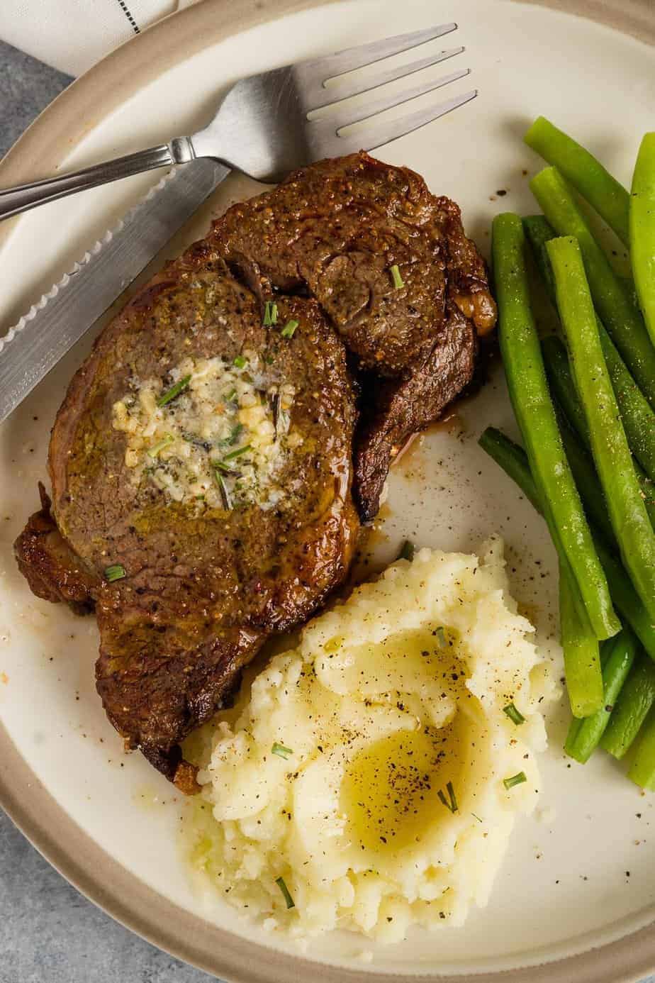 Ribeye served with sides of mashed cauliflower and green beans