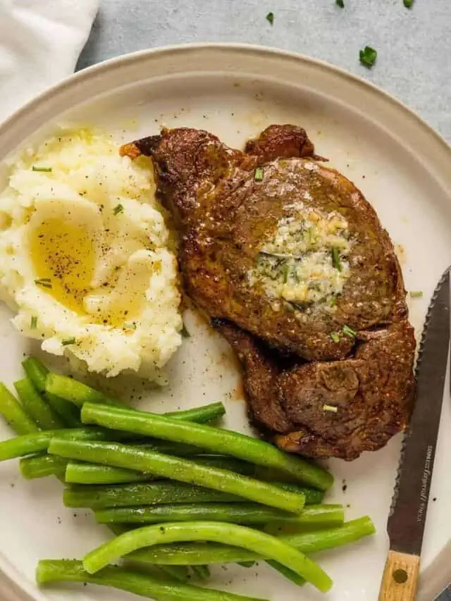ribeye steak in the air fryer served with mashed cauliflower and steamed green beans