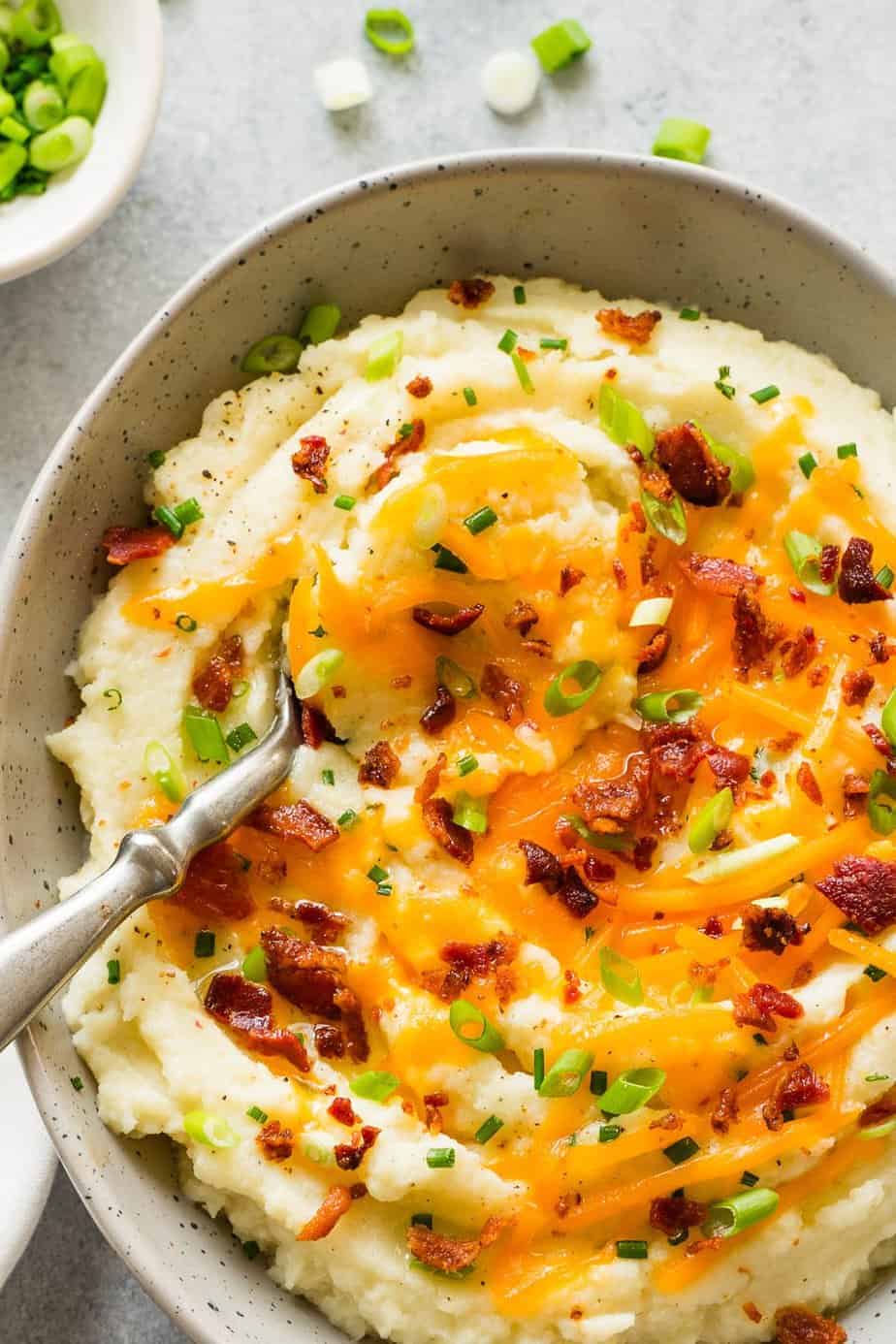 instant pot loaded mashed cauliflower with melted cheese, crispy bacon and green onion 
