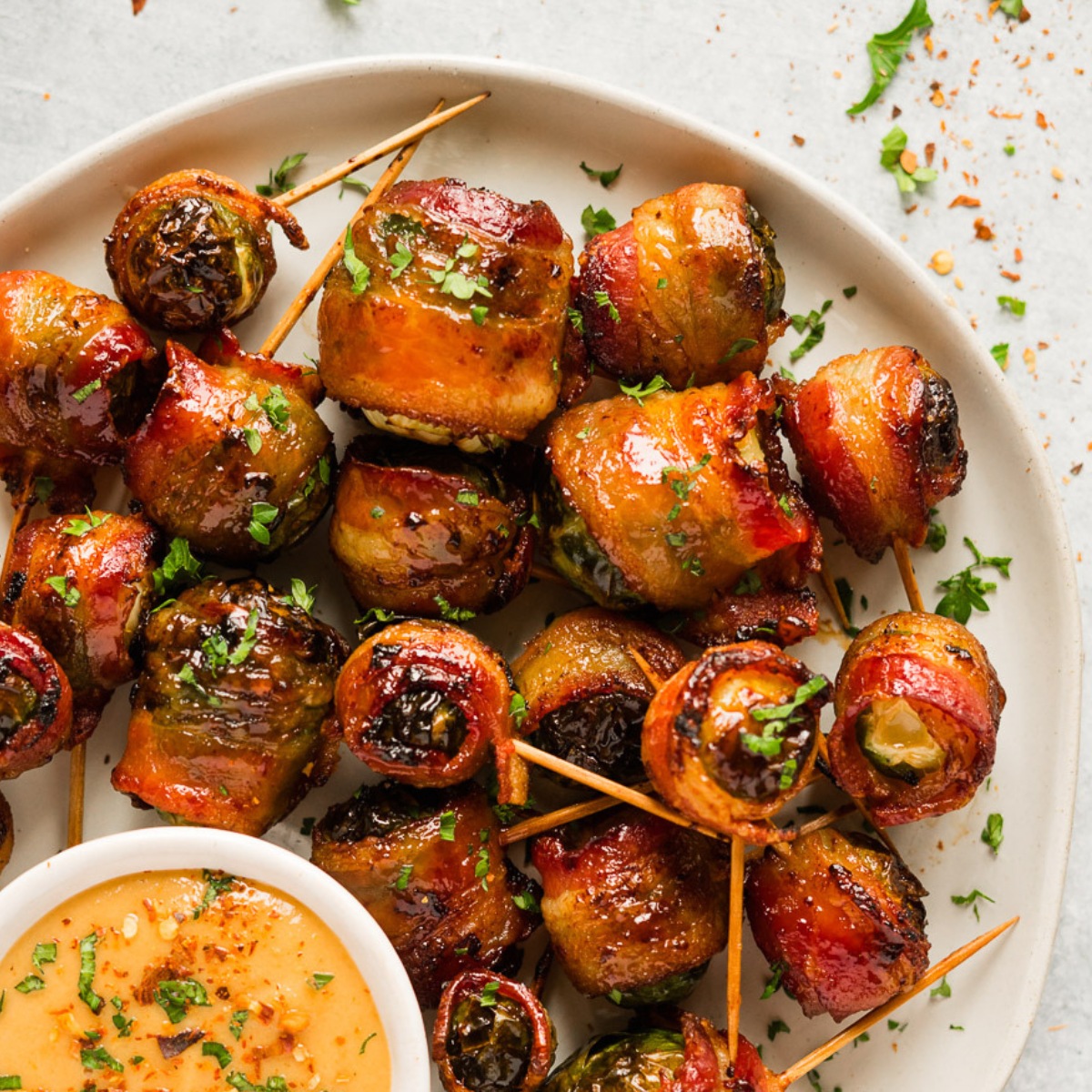 Air fryer bacon wrapped Brussels sprouts serve with tahini sauce.
