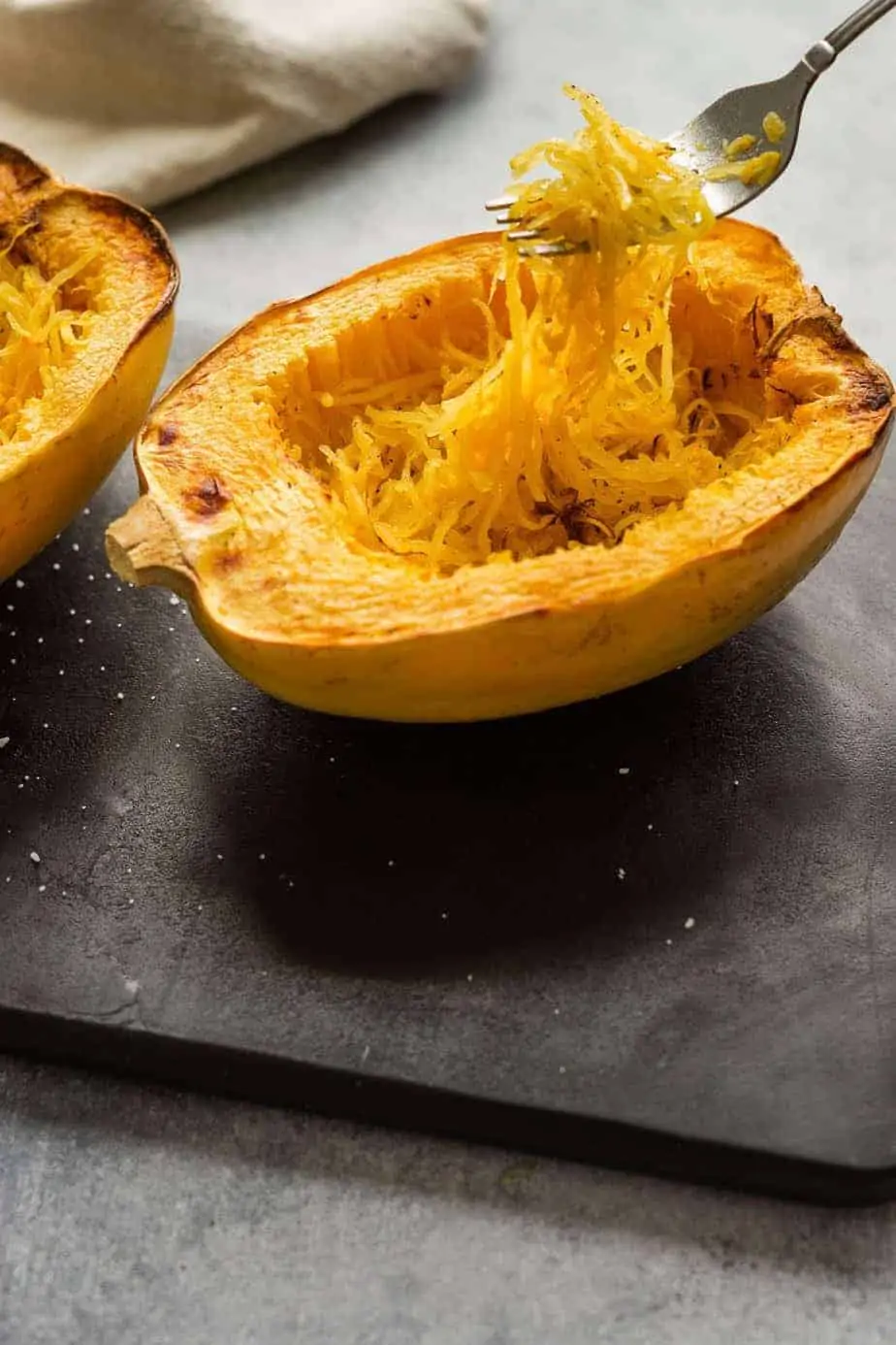 Air fryer Spaghetti squash holding the noodles with a fork.