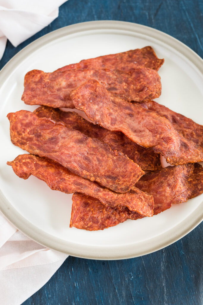 air fryer turkey bacon on a plate and a napkin on the side