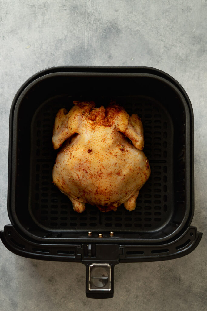 Cornish game hen in the air fryer basket before cooking.