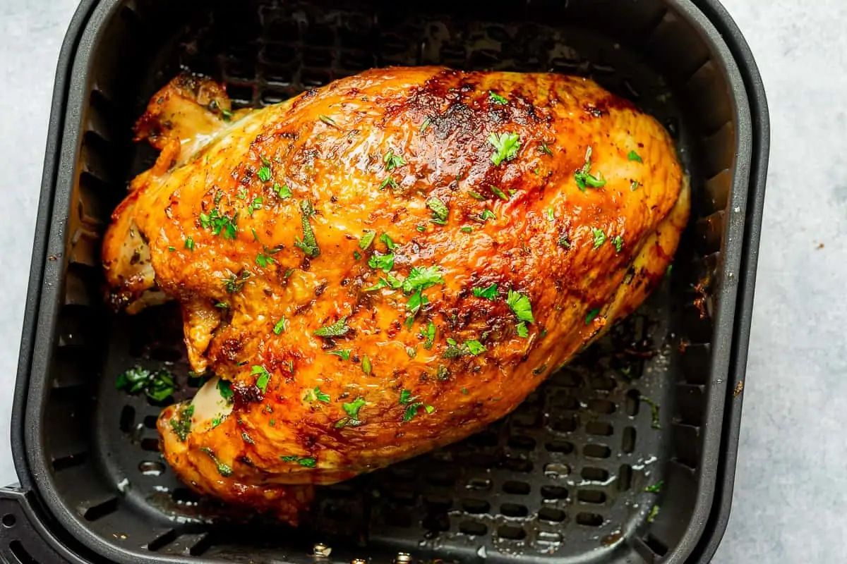 Air fryer turkey breast inside the air fryer basket after cooking.