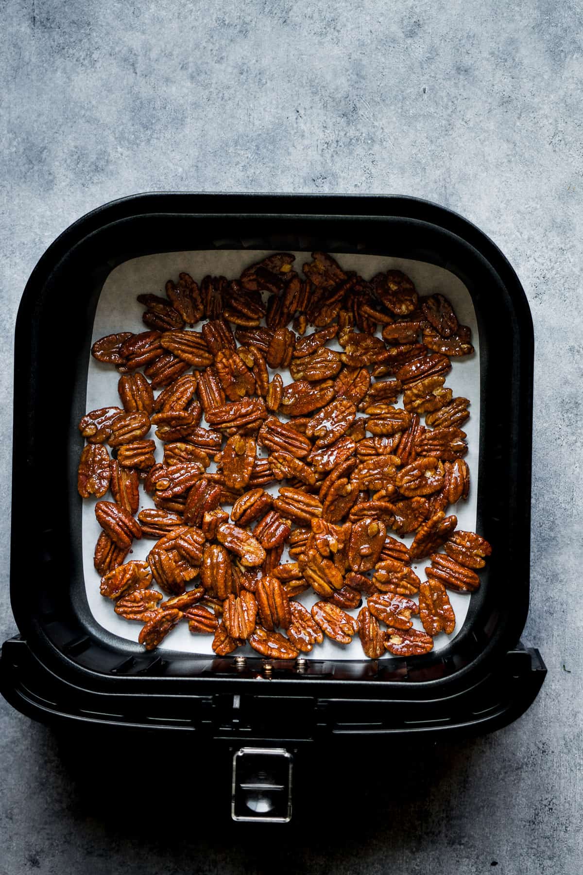 the seasoned pecans inside the air fryer basket.