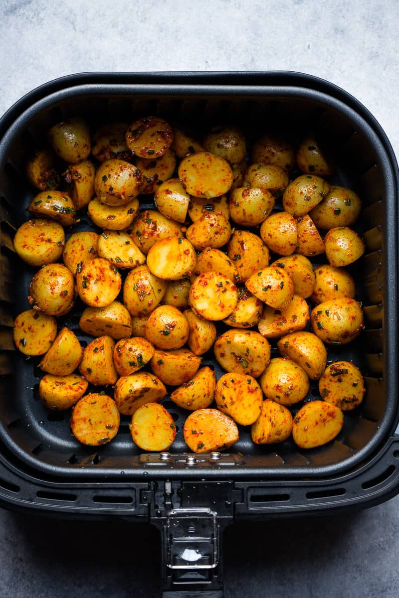 baby potatoes inside air fryer basket before cooking.