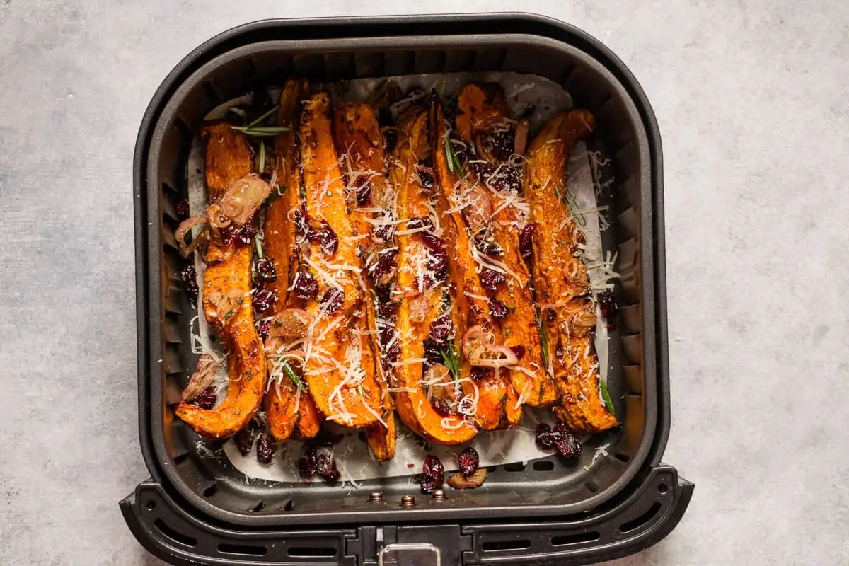 roasted butternut squash air fryer recipe. inside the basket with grated parmesan cheese.