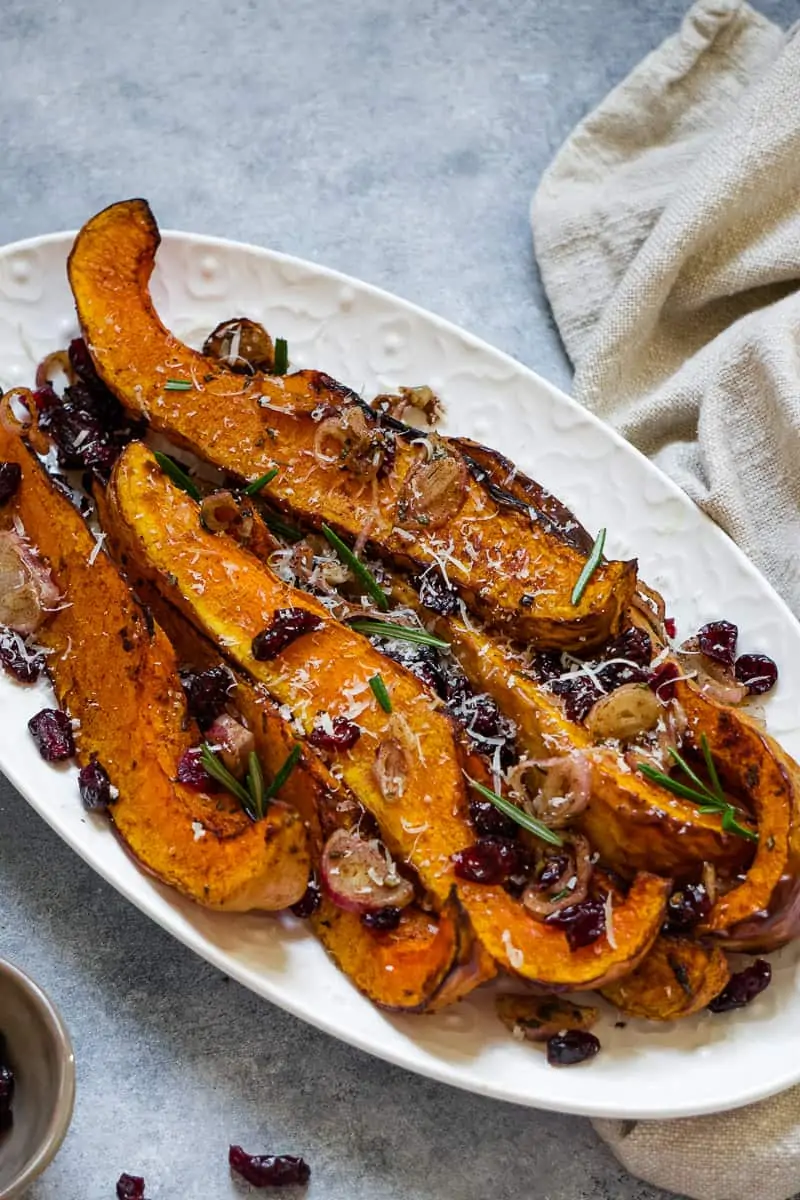 Air fryer butternut squash serve with parmesan cheese and dry cranberry.