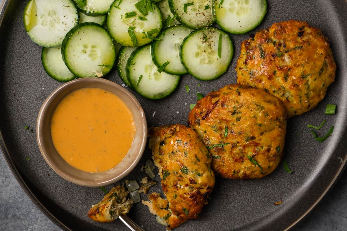 air fried salmon cakes serve with cucumber coins and dipping sauce.