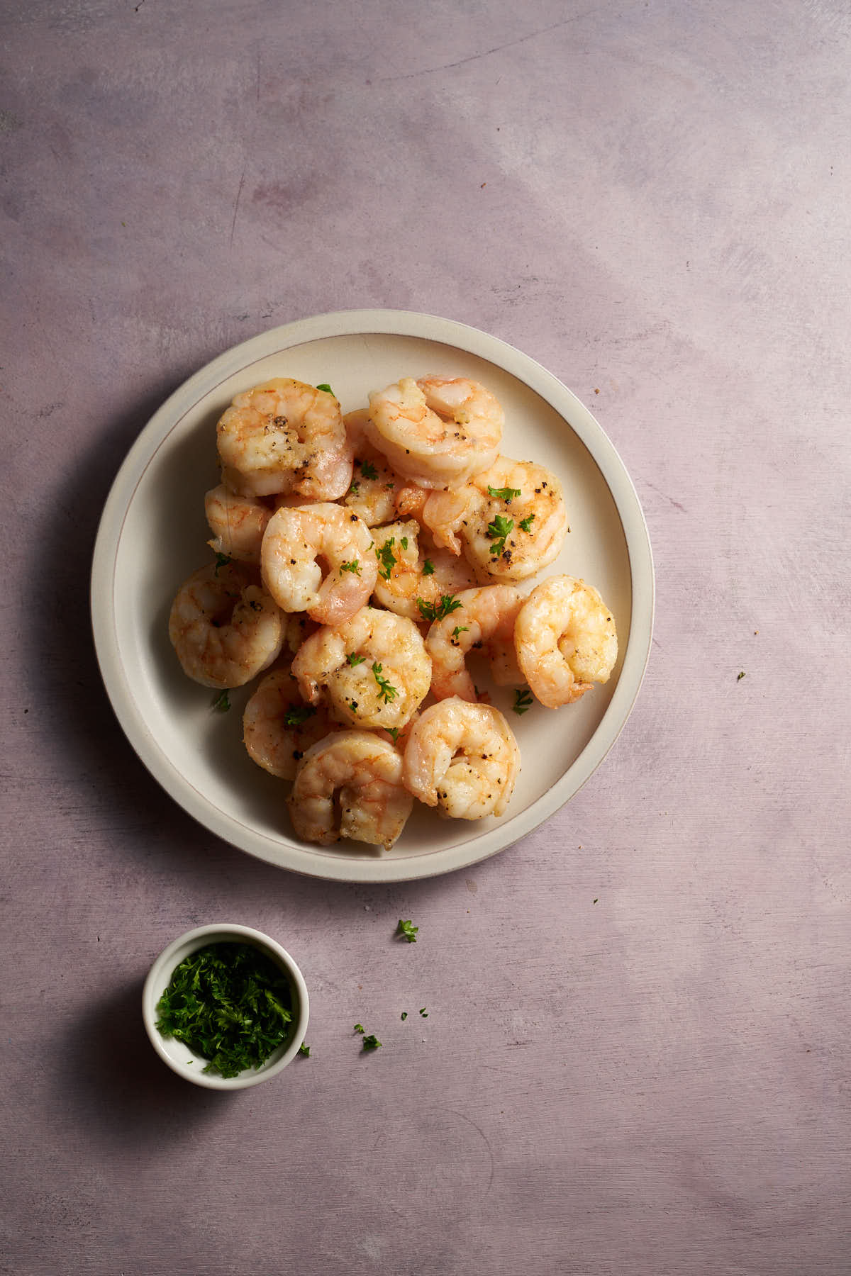 Air fryer shrimp served on a plate with parsley.