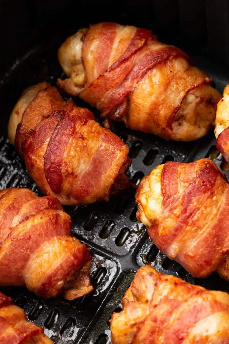 Air Fryer bacon-wrapped Chicken thighs in the basket.