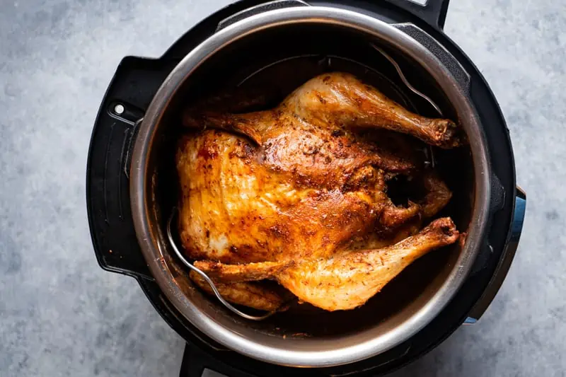 instant Pot air fryer lid Whole chicken inside the inner pot after cooking.