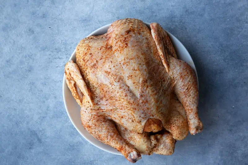 a whole chicken seasoned on all sides.