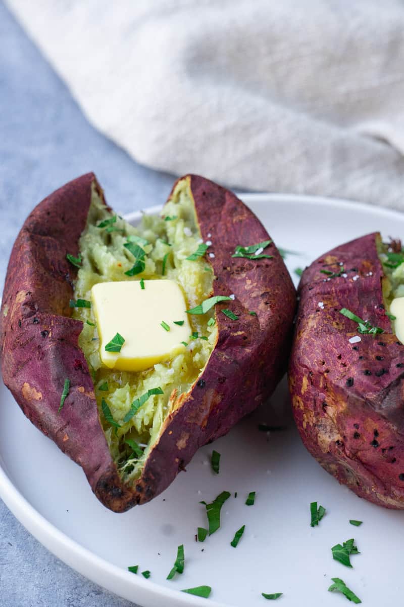 Perfectly cooked Japanese sweet potato air fryer. top with butter and fresh herbs.