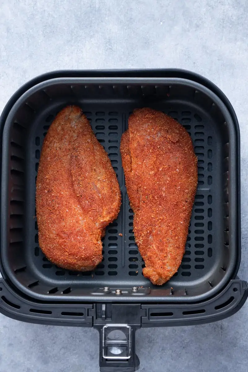 2 chicken breasts inside the air fryer basket.