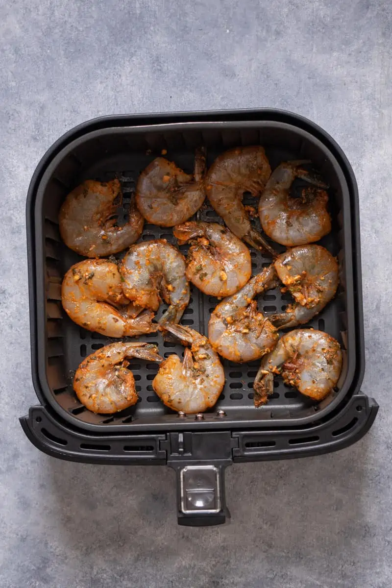Shrimp with shell in the air fryer basket before cooking