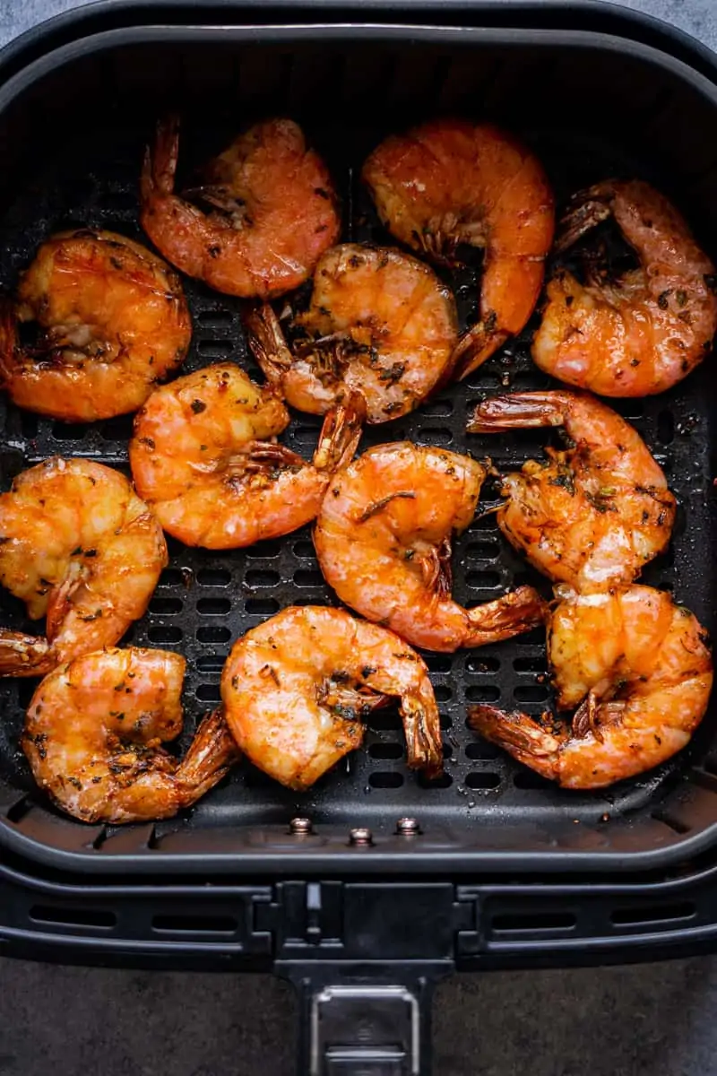 Shrimp with shell in the air fryer basket after cooking.