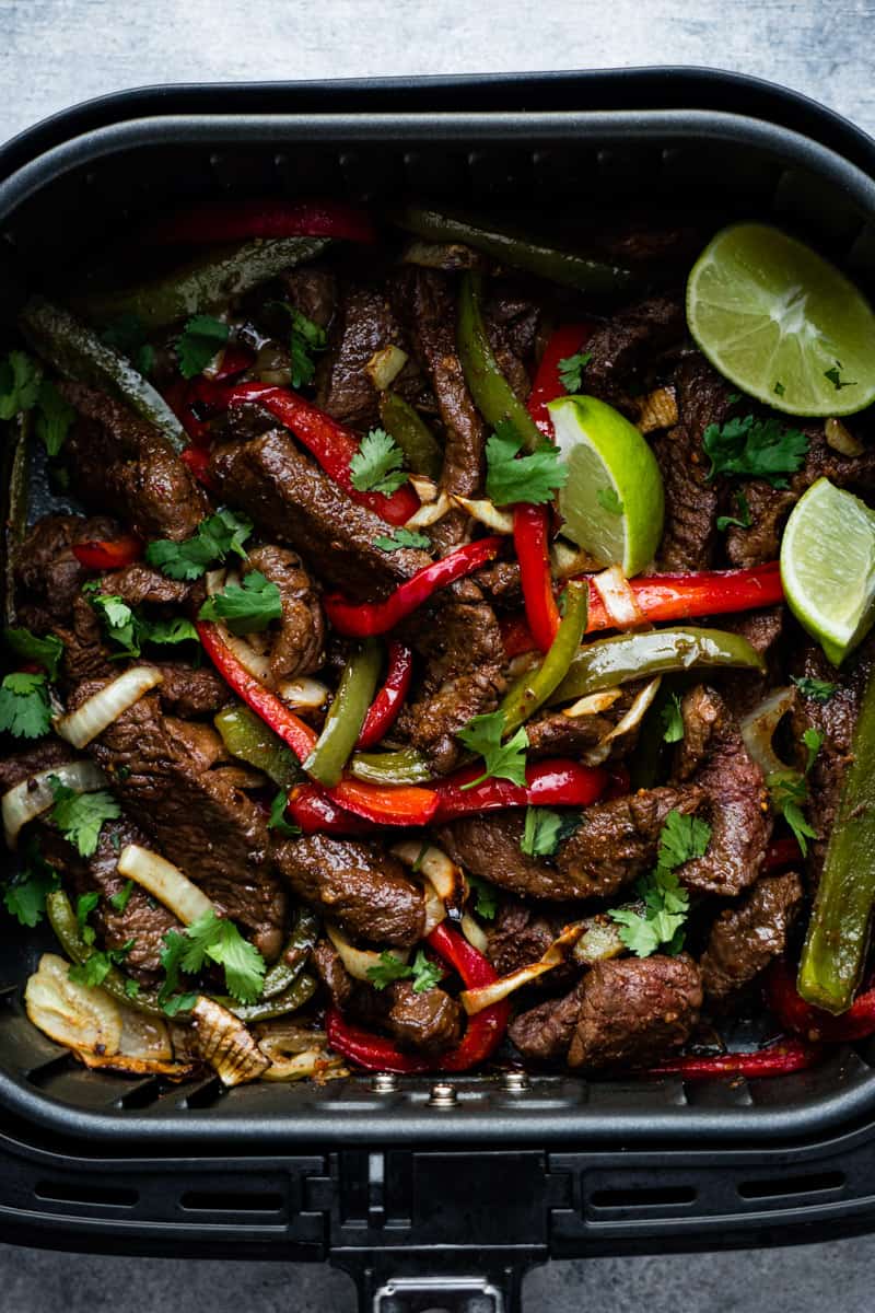Air Fryer steak fajitas. inside the air fryer basket and top with lime wedges and chopped fresh cilantro.