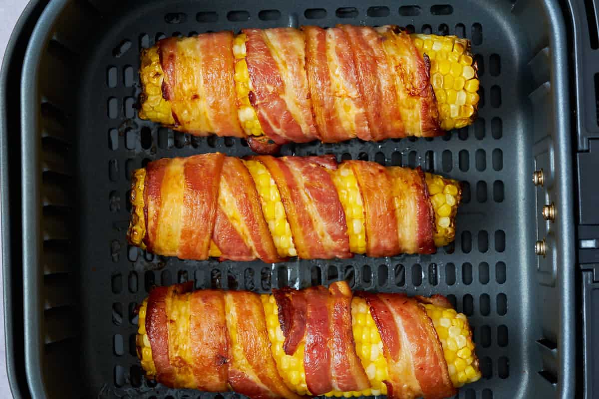 corn with bacon in the air fryer basket.