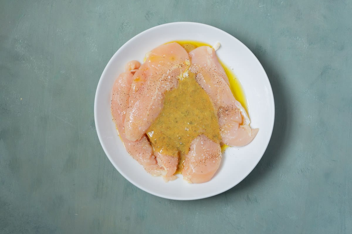 Uncooked chicken tenders coated with olive oil, salt, pepper, and the honey mustard mixture.