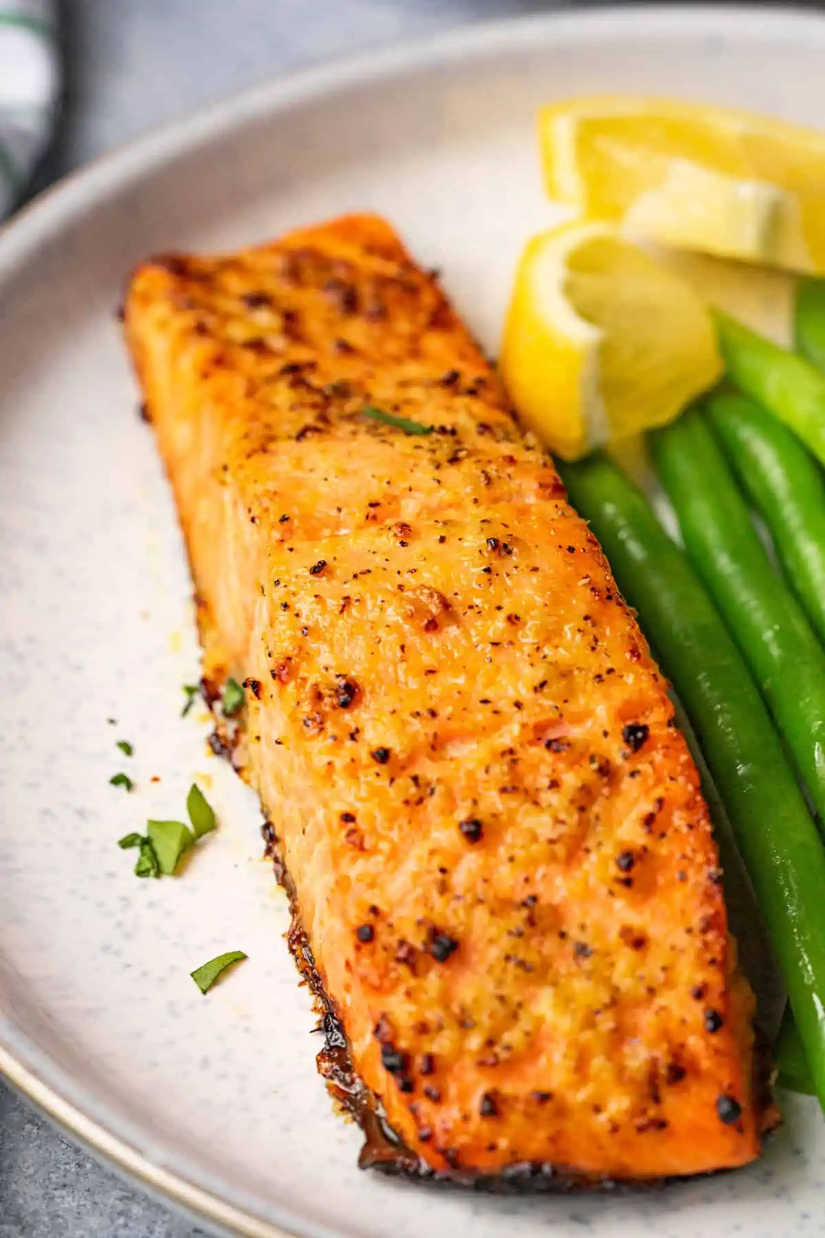  Salmon served with green beans and lemon.