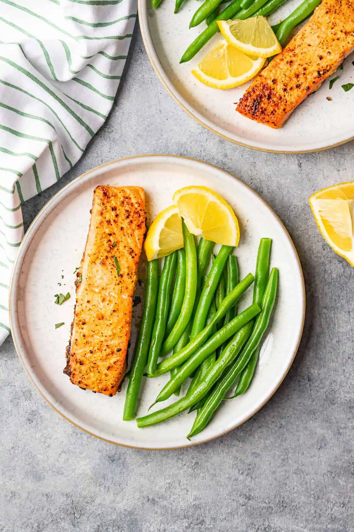 Lemon pepper salmon Air Fryer recipe served with green beans and  garnish with lemon.