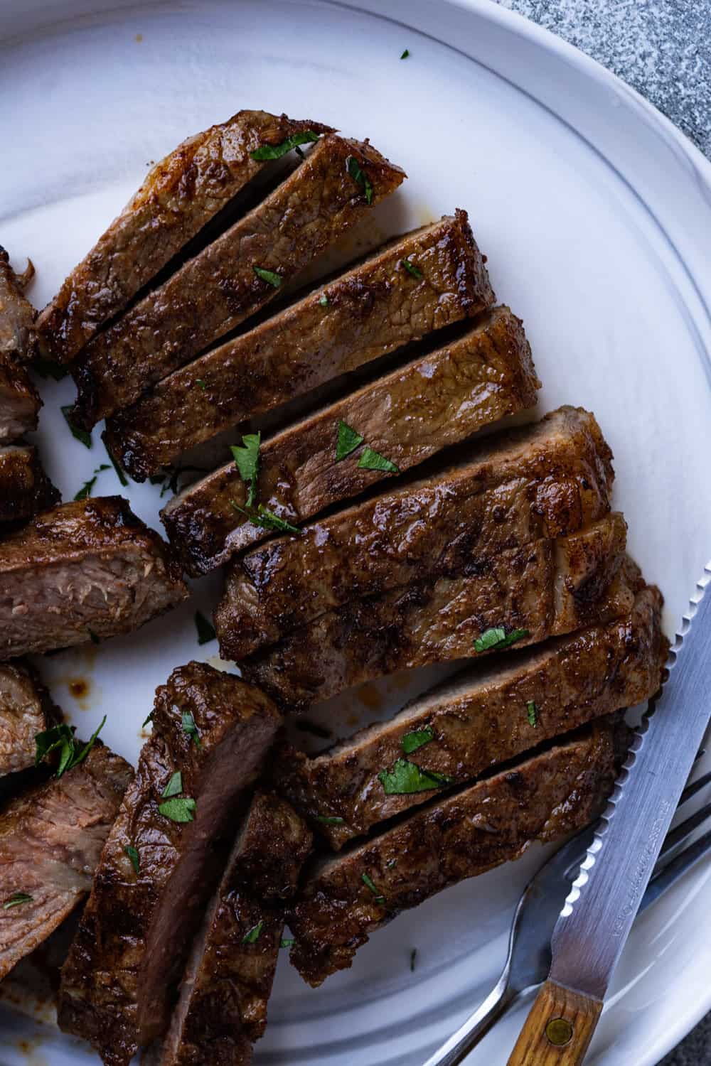 After resting the steaks are sliced on a plate.