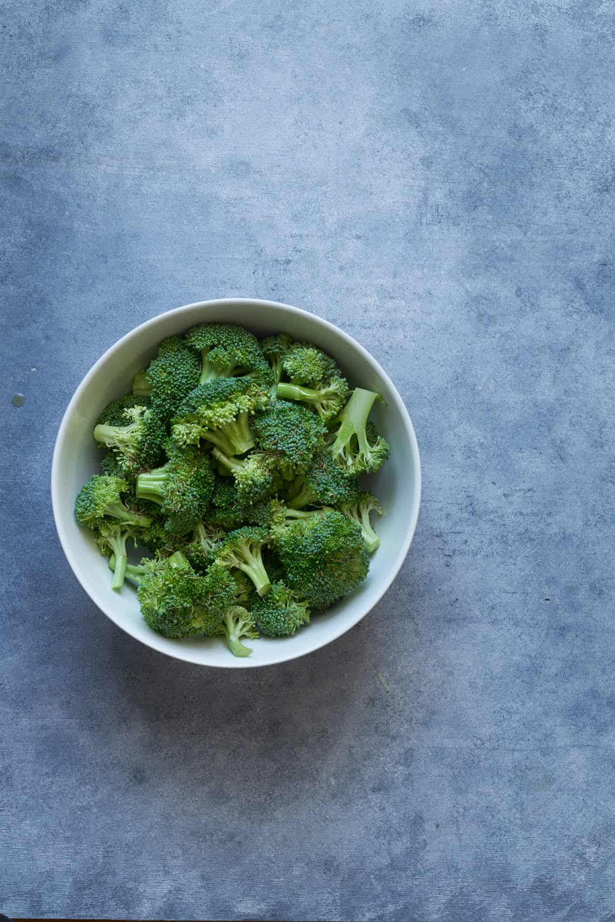 Broccoli, olive oil, and thyme in a bowl.
