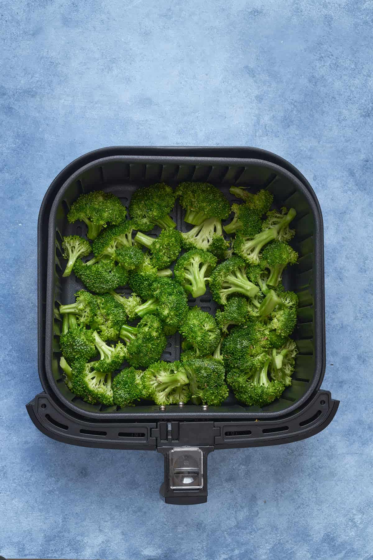 Uncooked broccoli in the air fryer.