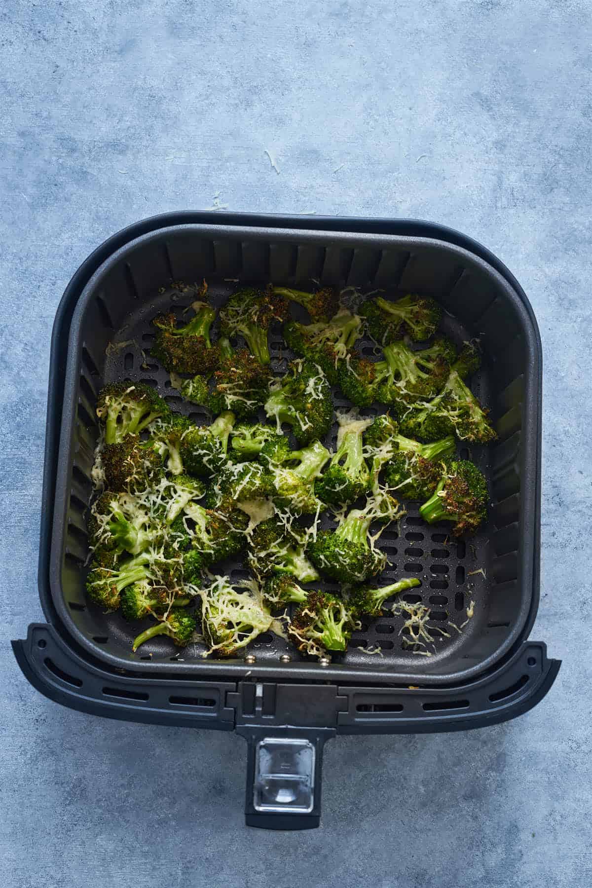 After air frying broccoli parmesan in the air fryer basket.