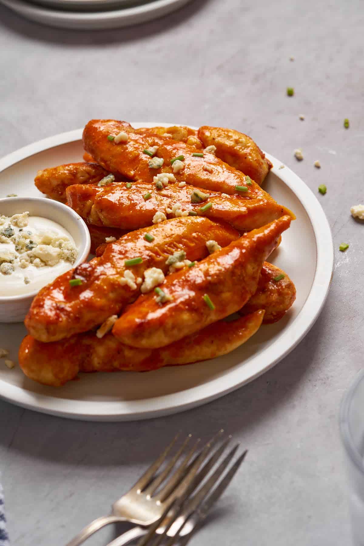Air fryer buffalo chicken tenders served with ranch salad dressing in a plate.