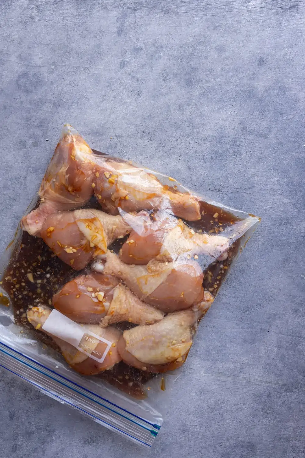 Chicken drumsticks marinating in a ziplock bag.