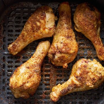 frozen chicken drumsticks in the air fryer basket.