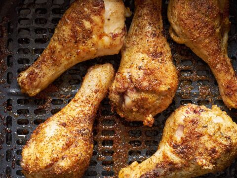 frozen chicken drumsticks in the air fryer basket.