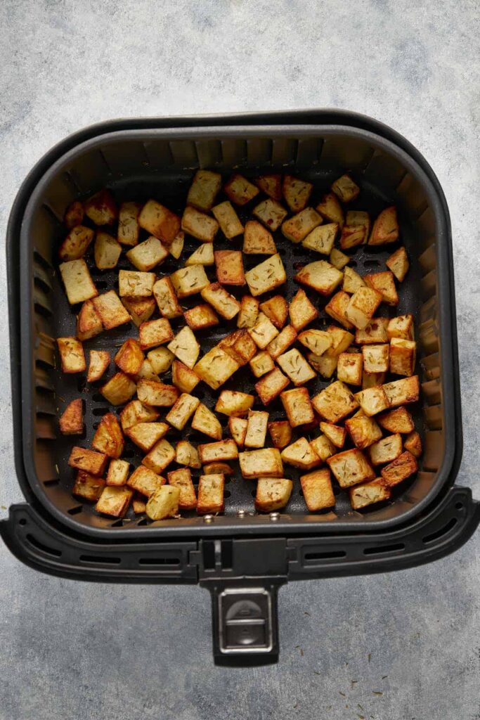 Air fried potatoes cubes in the basket.