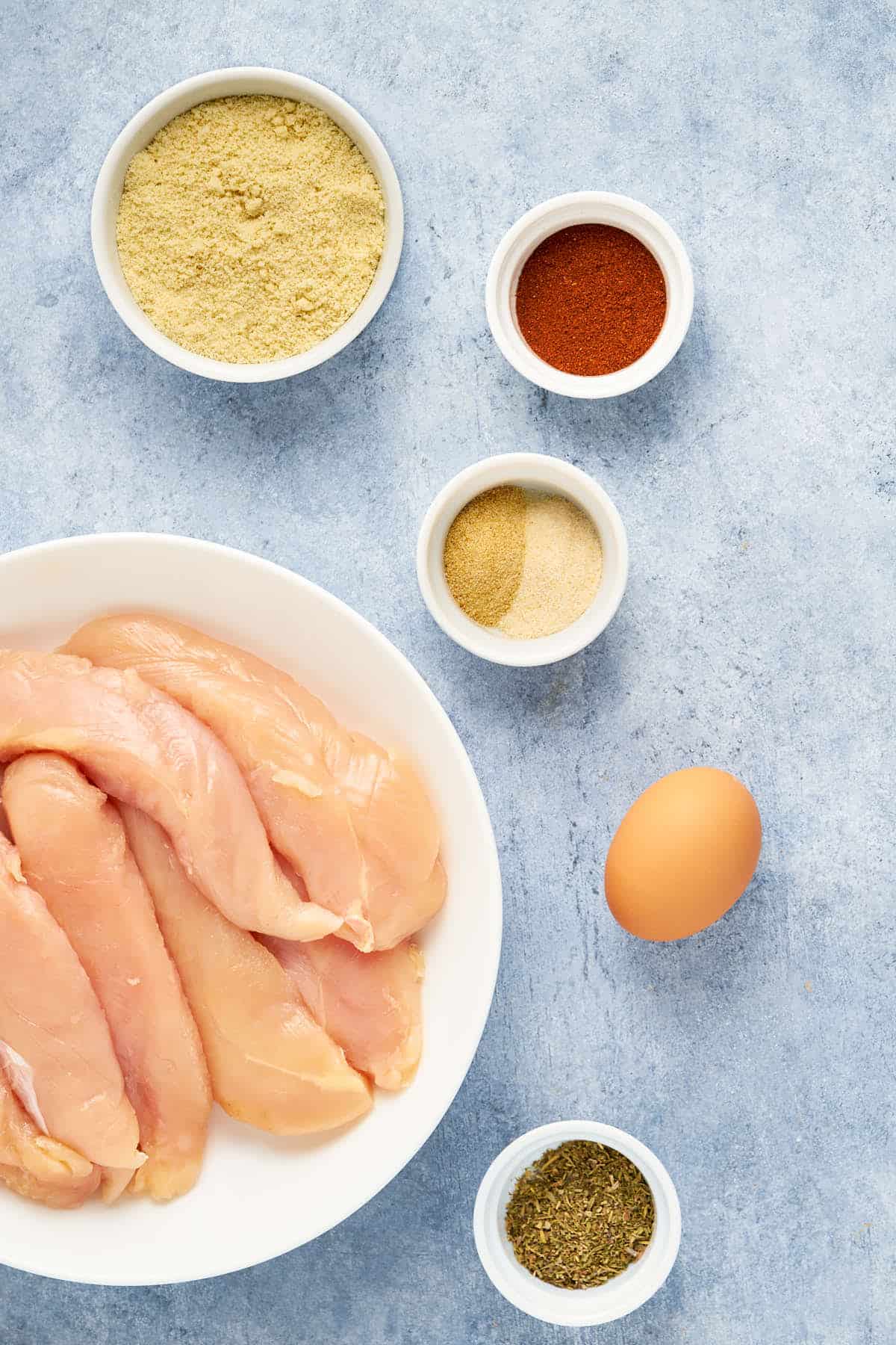 Ingredients to make crusted chicken tenders with almond flour.