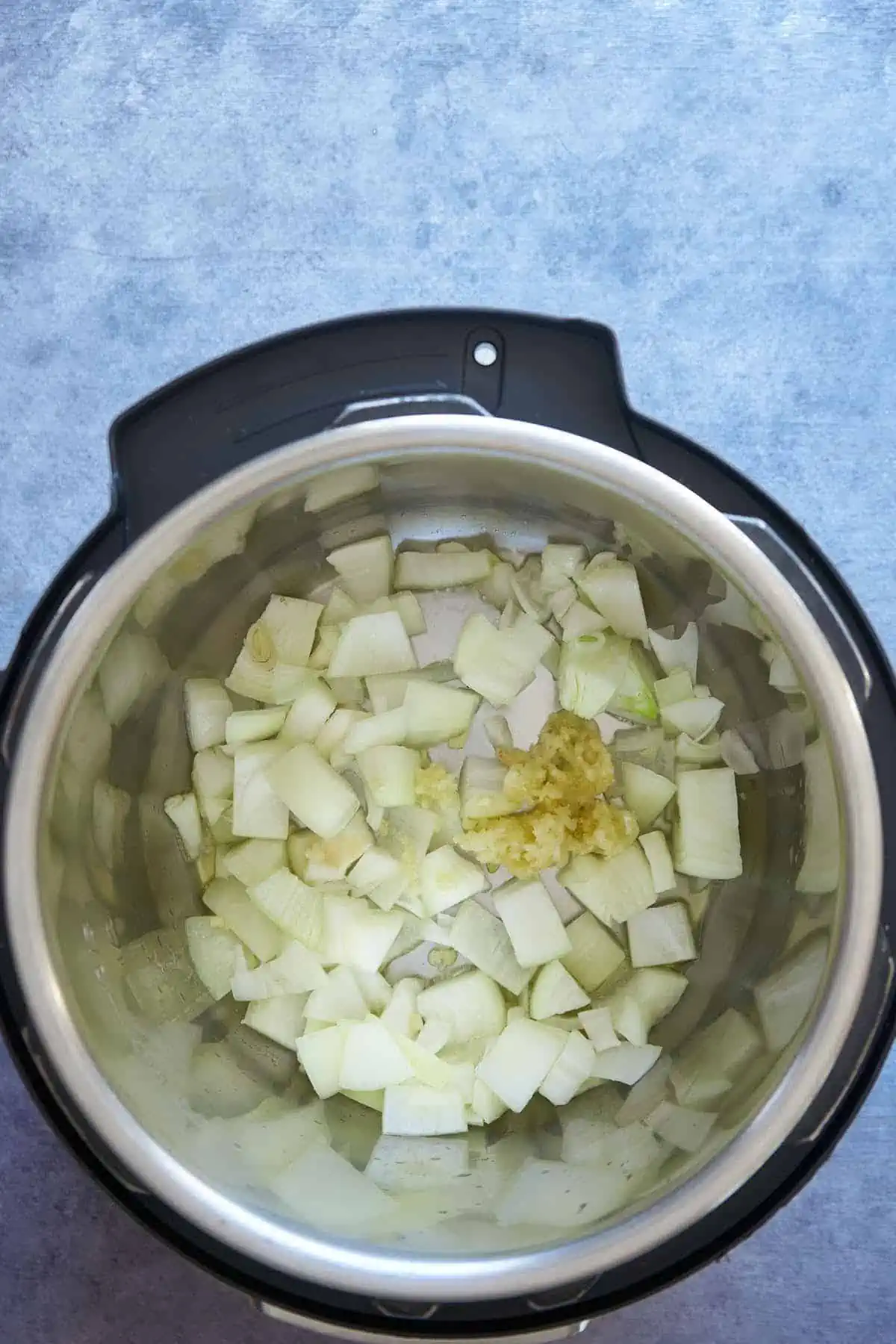 sautéing the onion and garlic in the inner pot.